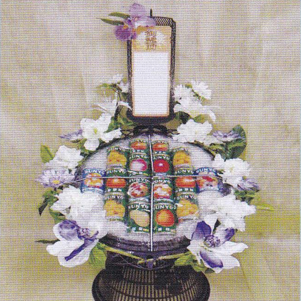 市川市の藤井祭典で提供する周囲に白や紫の花が美しく飾られ、缶ジュースで作られている籠