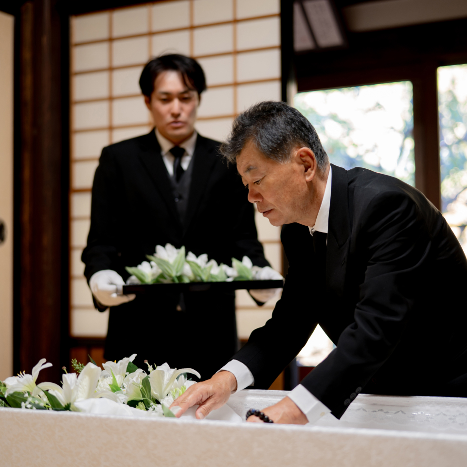 練馬区のみなと式典で葬儀をしている方が棺に花を添えている写真