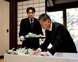 練馬区のみなと式典で葬儀をしている方が棺に花を添えている写真