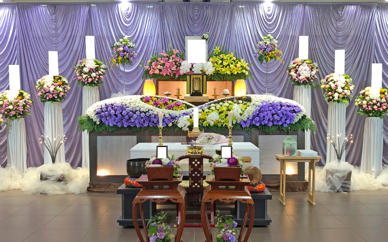 練馬区のみなと式典の家族葬の白や紫の花で飾られた祭壇と遺影の写真