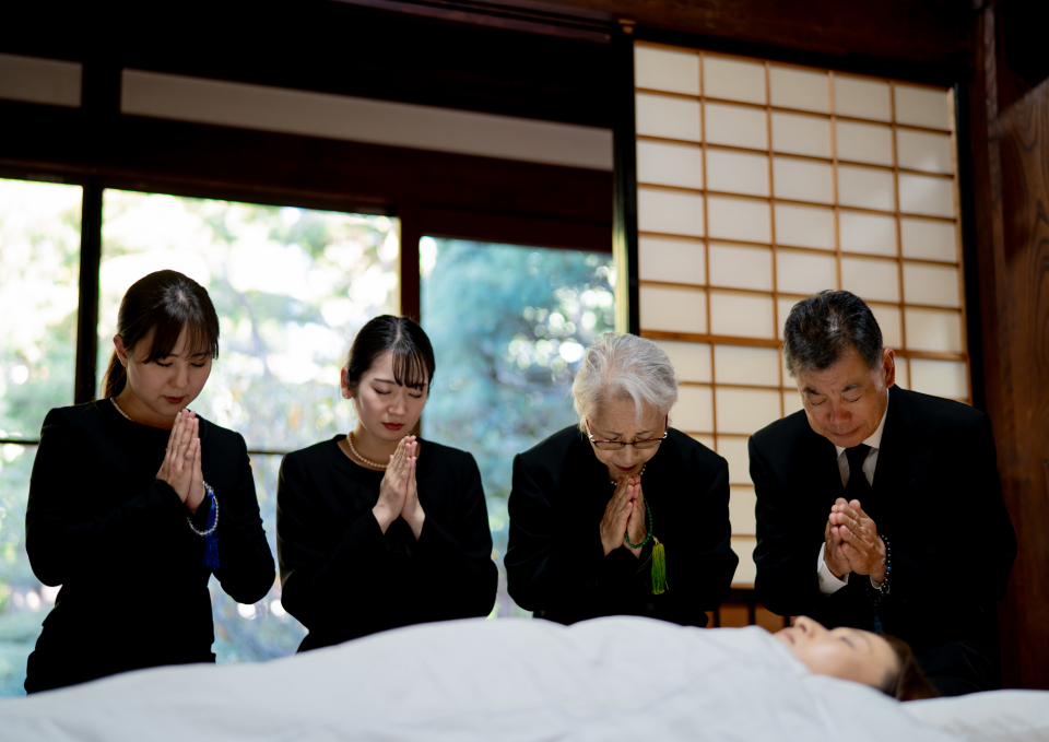 練馬区のみなと式典ので葬儀をしている方が手を合わせて祈りを捧げている写真