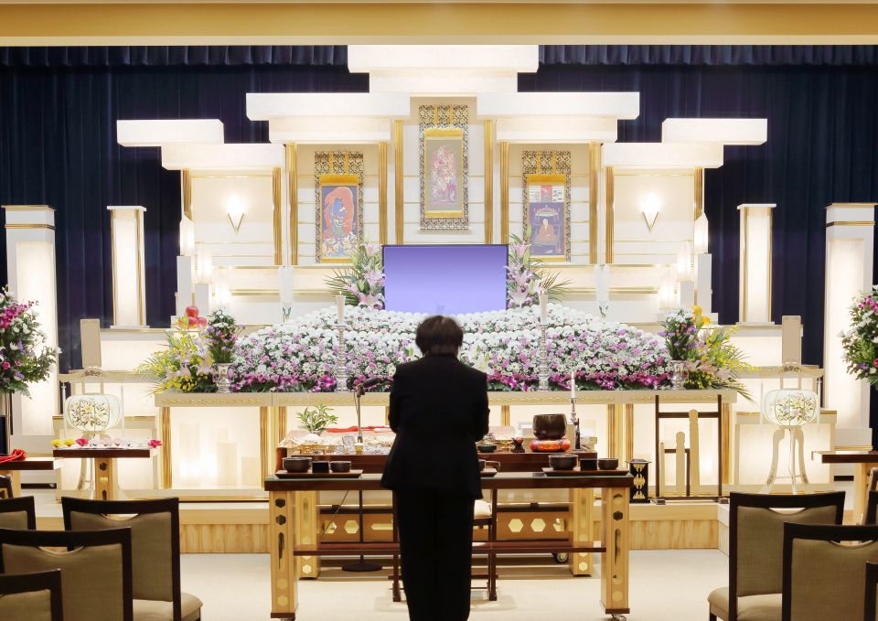 練馬区のみなと式典の祭壇の前で祈りを捧げている男性の写真