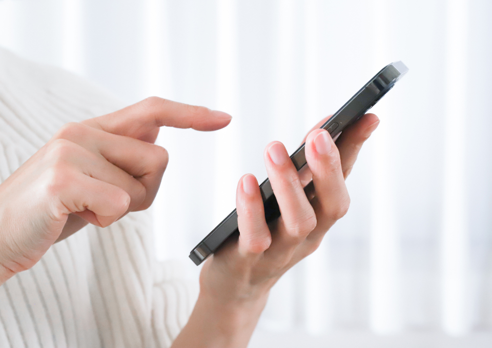 練馬区のみなと式典を検討してる方がスマートフォンを操作する手元の写真